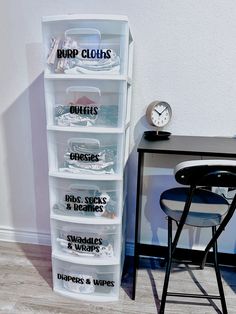 a stack of plastic containers sitting on top of a wooden floor next to a desk