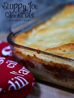 a casserole dish sitting on top of a table next to a red oven mitt