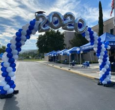 an arch made out of balloons with the number 20 on it in front of a building