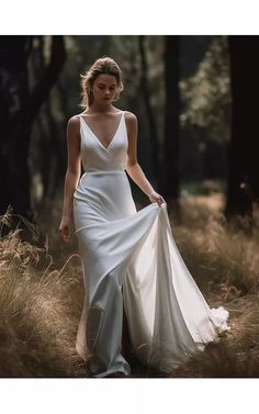 a woman in a white dress walking through tall grass