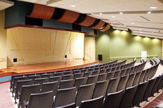 an empty auditorium with rows of chairs facing the stage