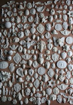 many different white ceramic items are arranged on a brown table top, and there is no image here to provide a caption for