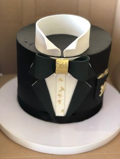 a black and white cake with a gold bow tie on it's lapel