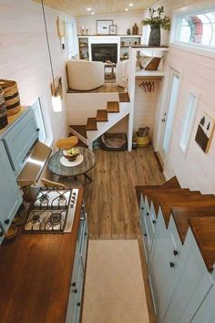 the interior of a tiny home with stairs leading up to the kitchen and living room