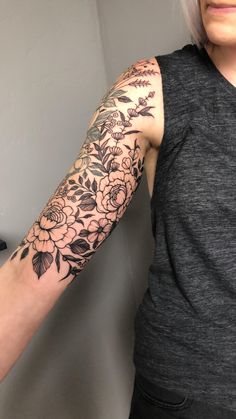 a woman with grey hair has a flower tattoo on her arm