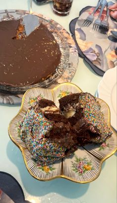 a table topped with two plates filled with cakes and desserts covered in sprinkles