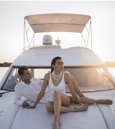 a man and woman sitting on the back of a boat