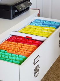 the drawers are filled with colored plastic blocks and a printer is on the table in the background