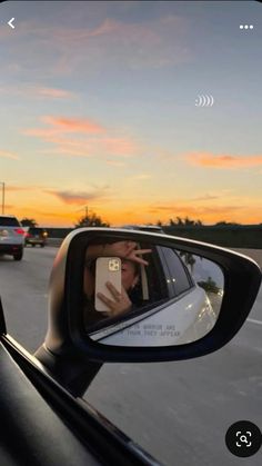 someone taking a selfie in the side mirror of a car at sunset or dawn