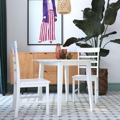 a table and two chairs are in front of a potted plant on the floor