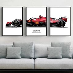 three red race cars hanging on the wall in a living room with grey couches