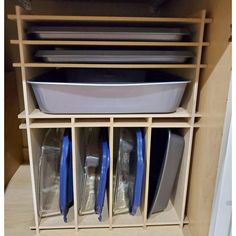 an organized shelf with dishes and pans in it