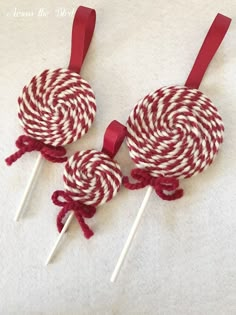 red and white lollipops are sitting on top of each other with ribbons