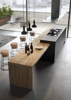 a modern kitchen with an island counter and stools in front of the stove top