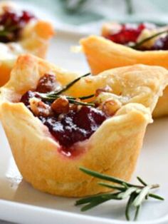 mini cranberry tarts with rosemary garnishes on a white plate