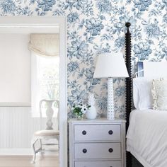 a bedroom with blue and white floral wallpaper