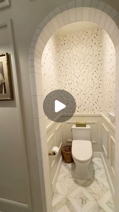 a white toilet sitting inside of a bathroom next to a doorway