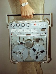 a person holding an old fashioned radio in their hand