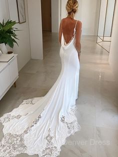 a woman in a white wedding dress looking at her reflection