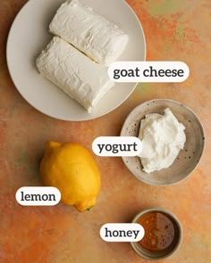 there are three different types of cheese on the plate next to lemons, yogurt and honey