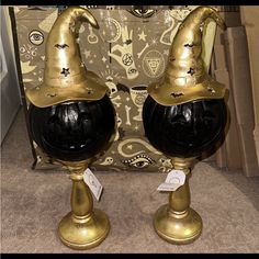 two black and gold vases sitting on top of a carpeted floor next to a cardboard box