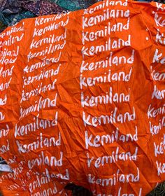 an orange piece of paper with words written in white on it sitting on the ground