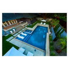 an aerial view of a backyard with a swimming pool and lounge chairs in the foreground