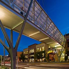 a pedestrian bridge over a city street at night