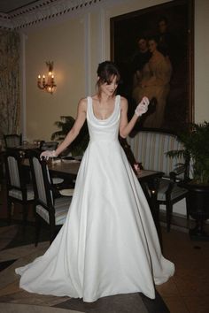 a woman in a white wedding dress holding her hand out