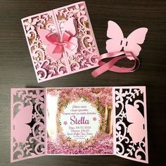 the inside of a pink card with butterfly cut outs and ribbon on it, sitting next to another card