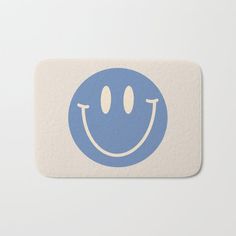 a blue smiley face with two eyes on a white background bath mat, featuring an image of a smiling face