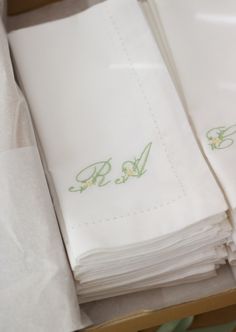 a stack of folded white napkins sitting on top of a wooden table next to each other