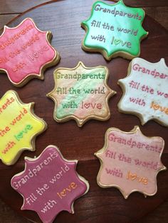 decorated cookies with words on them sitting on a wooden table in the shape of stars