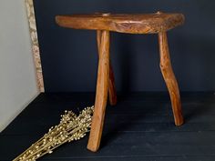 a small wooden stool next to some dried flowers