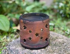 a brown and black ring with stars on it sitting on a rock in the grass