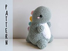 a small crocheted stuffed animal sitting on top of a table next to a white wall