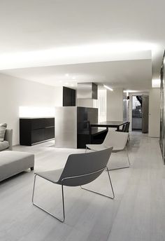 a modern living room with white walls and wood flooring is pictured in this image