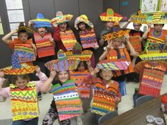 a group of children holding up colorful art pieces