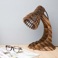 a pair of glasses sitting on top of a wooden table next to a magazine holder