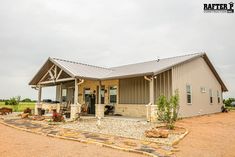 a small house with a metal roof and stone walkway