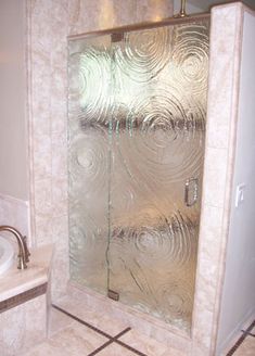 a glass shower door in a bathroom next to a sink