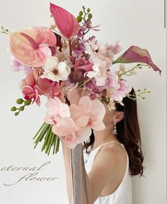 a woman holding a bouquet of flowers in front of her face with the words eternal love written on it