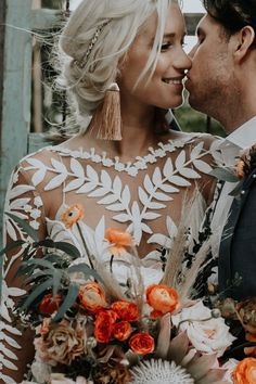 a bride and groom standing close to each other with flowers in their bouquets on their wedding day