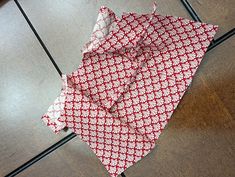 a red and white tie laying on top of a wooden floor