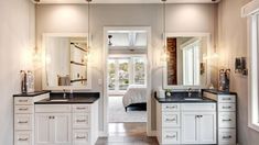 a bathroom with double sinks, mirrors and lights on the ceiling is shown in this image