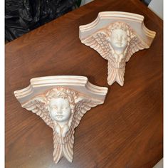 two decorative wall shelves on top of a wooden table