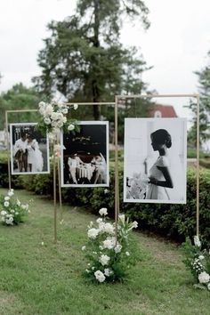 wedding decorations with pictures and flowers on them in front of some bushes at the end of an aisle