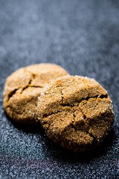 two cookies sitting on top of a black table