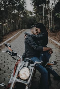 two people are sitting on a motorcycle together