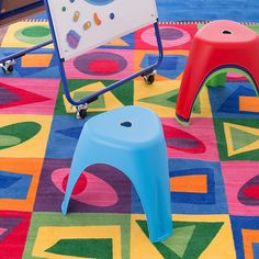 two children's chairs and a play table on a colorful rug